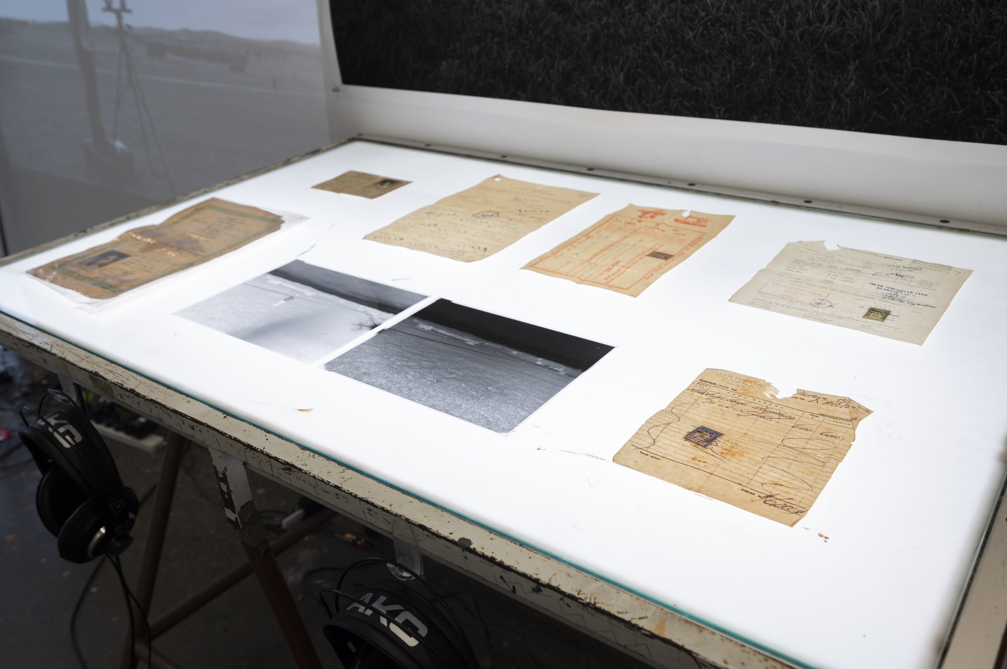 Mixed media installation consists of moving image, sound, family archive documents, photograph, and negatives