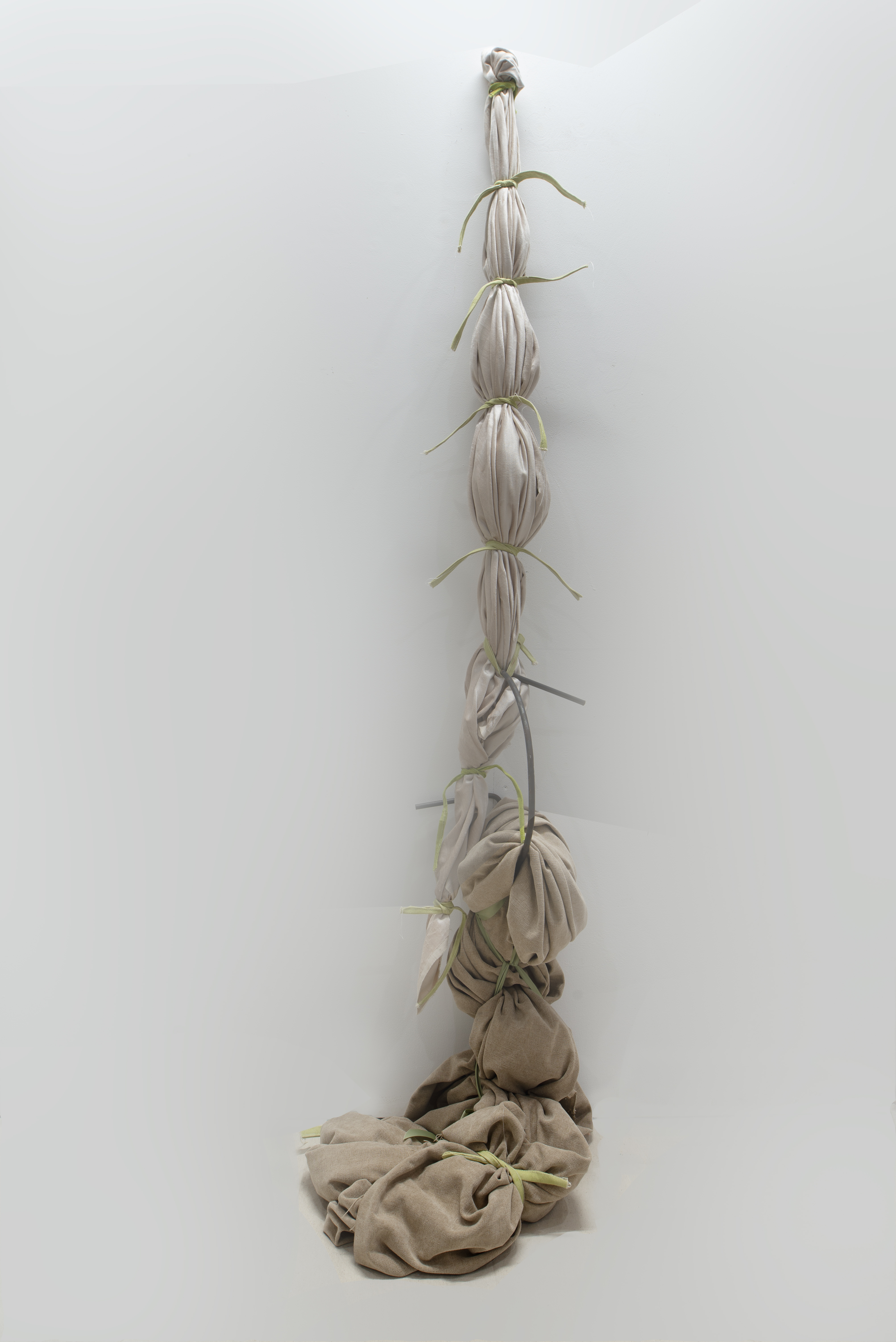 'Soft Earth', 2024. Textiles and stained canvas , iron rod 
