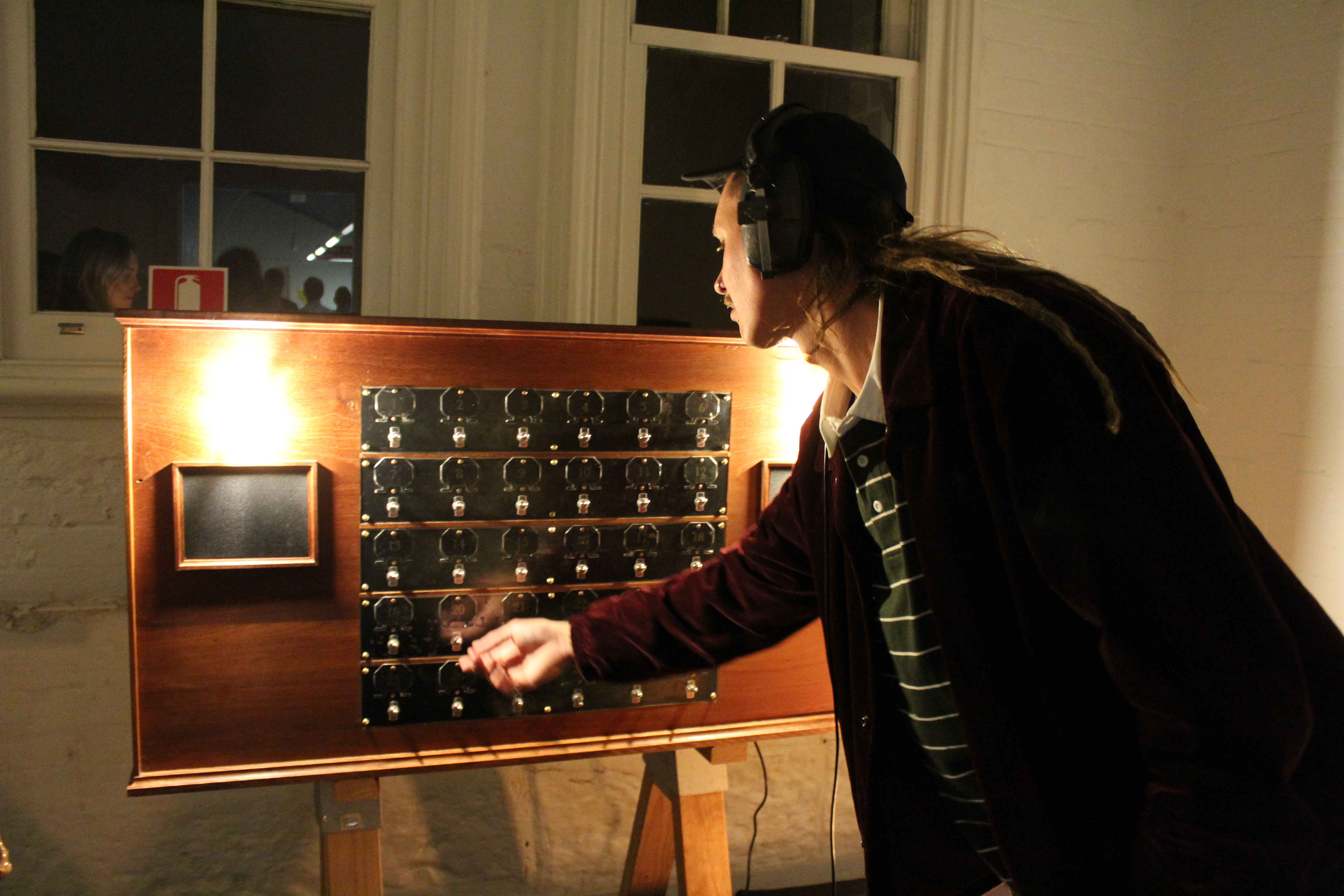 Abigail Montgomery “A Sum of Its Parts: Abi’s Switchboard” 2023, Wood, Steel, Toggle Switches, Arduino Microprocessor, Speaker Drivers, Wires, Computer