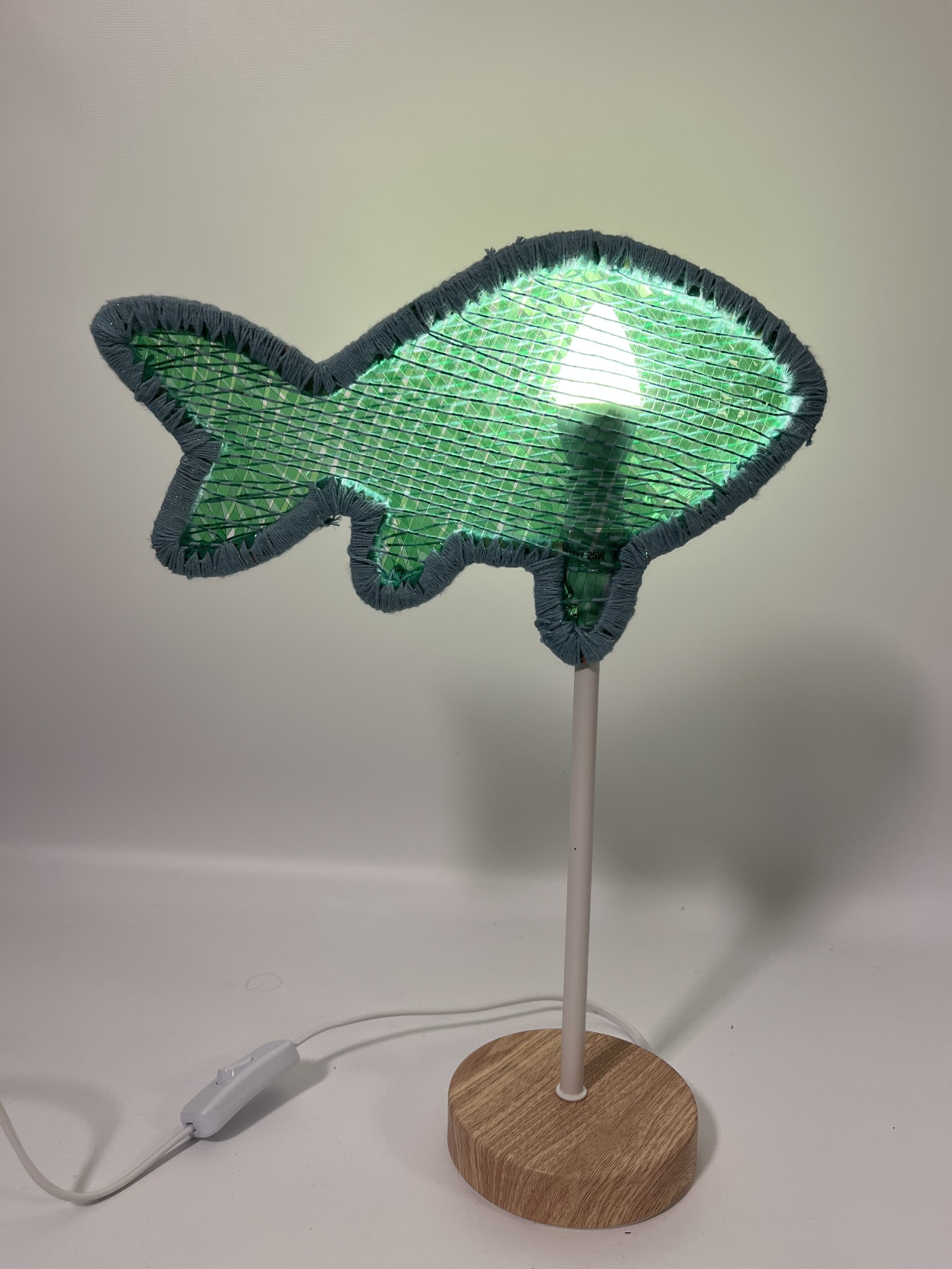'Tilapia Fish Lamp', 2025. Upcycled PET bottle yarn, laser-cut wood, weaving and basketry techniques, LED light