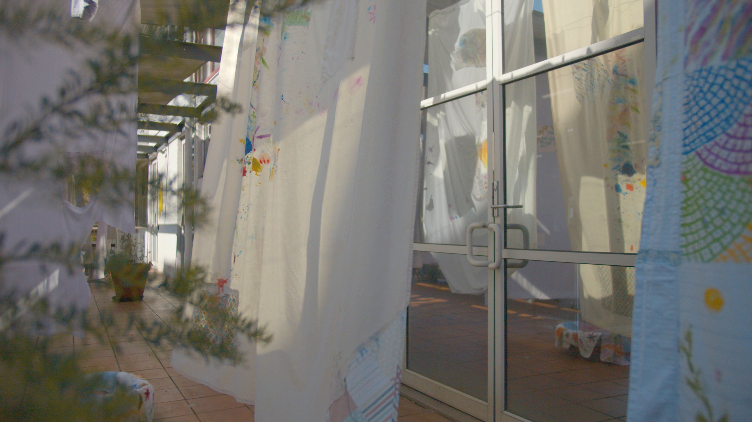 'I will hold you (and all your frayed edges)', 2025. Installation, used bedsheets, poetry, conversation, embroidery, fabric paint.