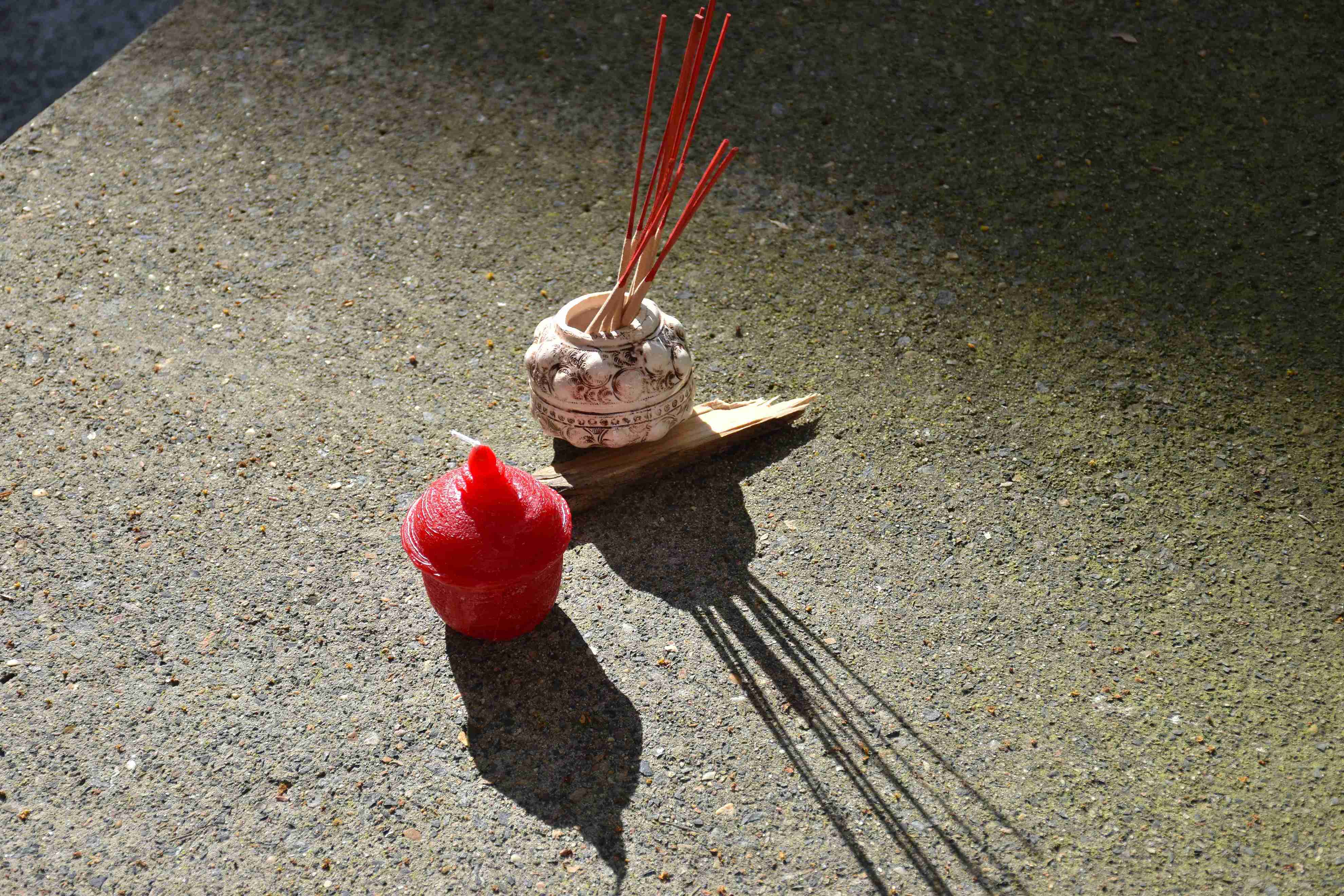 'meld into the shape of mother's motherland', 2025. Wax, lamp wick, slip clay, manganese oxide, satin white glaze, found wood