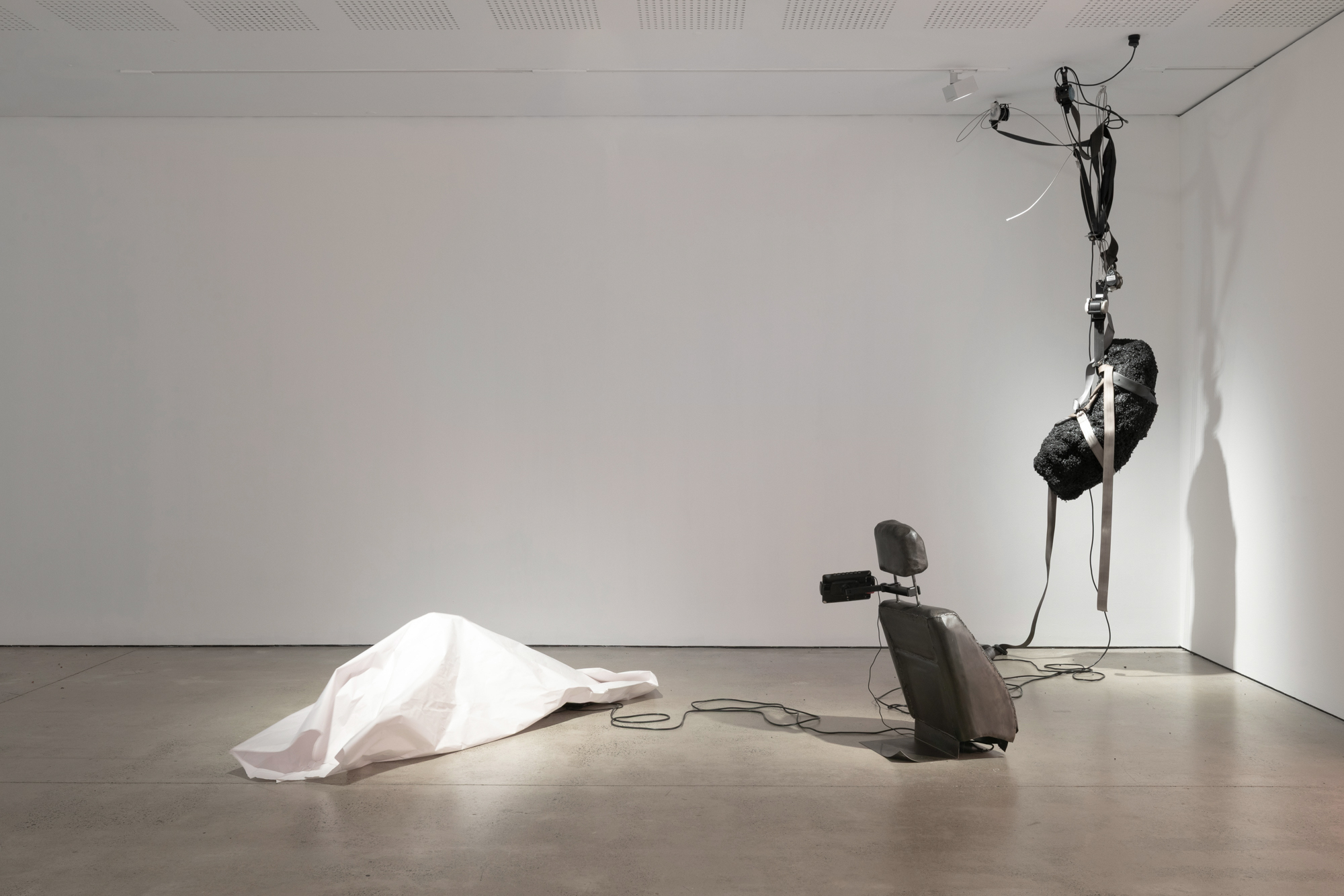  'Passenger Princess', 2025. Installation, video, steel, bitumen, paper, seat belts, electric motor.