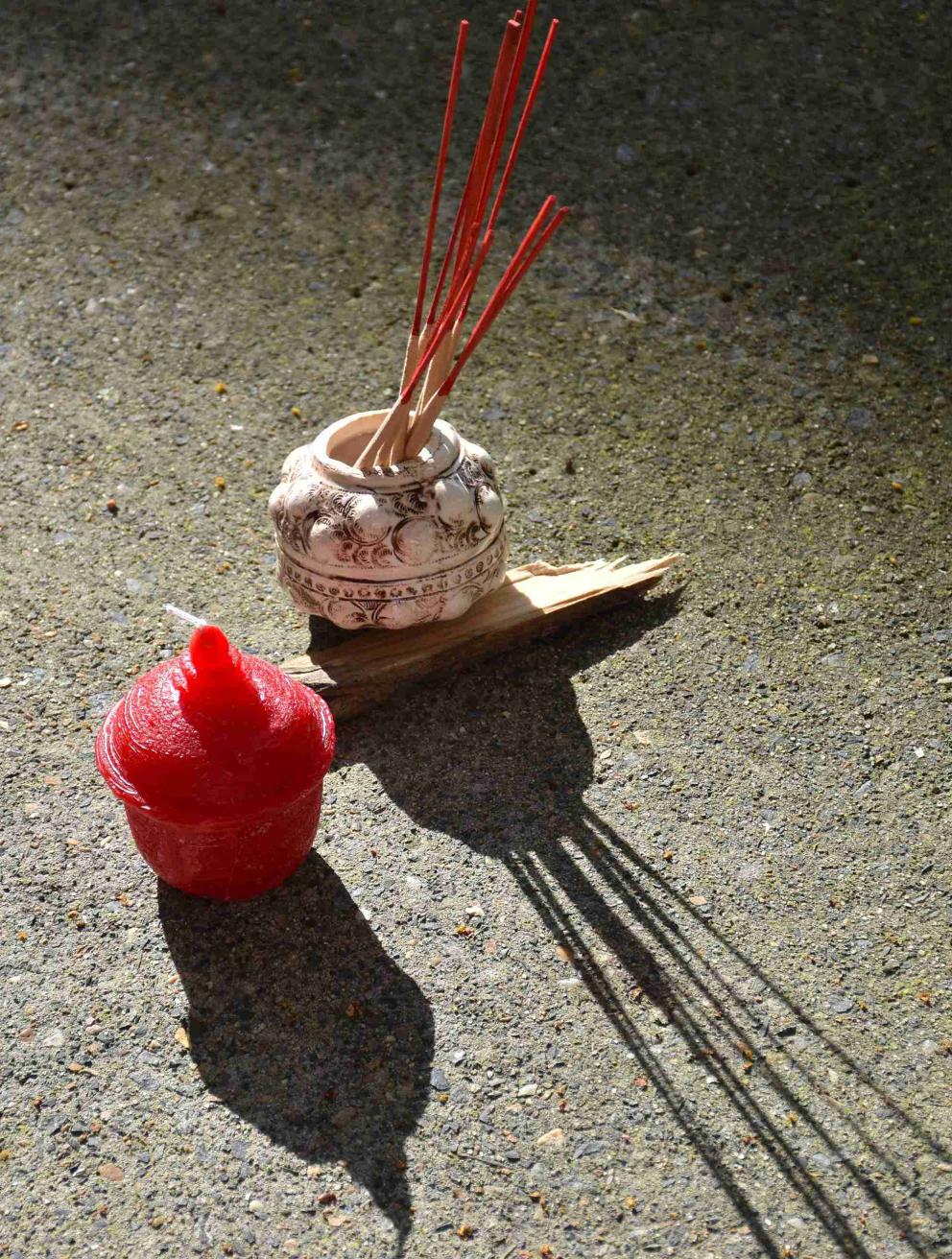 'meld into the shape of mother's motherland', 2025. Wax, lamp wick, slip clay, manganese oxide, satin white glaze, found wood