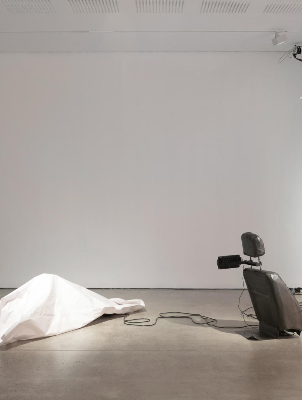 'Passenger Princess', 2025. Installation, video, steel, bitumen, paper, seat belts, electric motor.