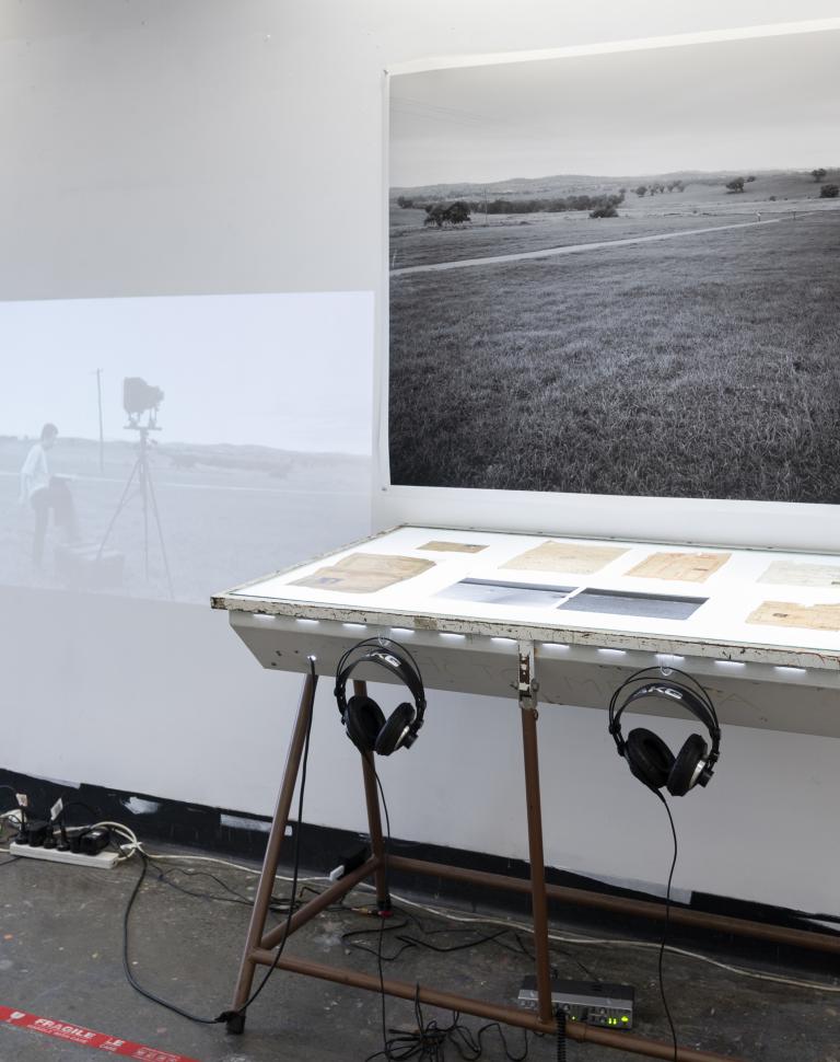 Mixed media installation consists of moving image, sound, family archive documents, photograph, and negatives.